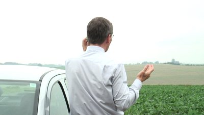 Man on a phone next to a car