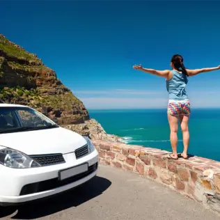 A lady with a car rental overlooking the sea