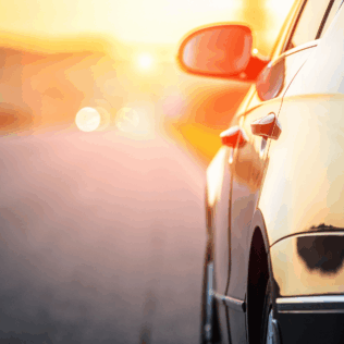 This is an image of a black vehicle driving towards a sunset background - this will augment the article which is titled: Car rental plugs: South Africa